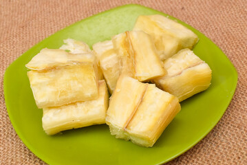 Steamed cassava served on green plate