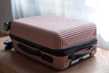 Pink suitcase on hotel bed. travel concept