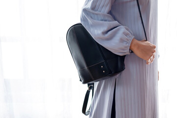 Side view of Muslim woman standing with sling bag on white background. Travel concept