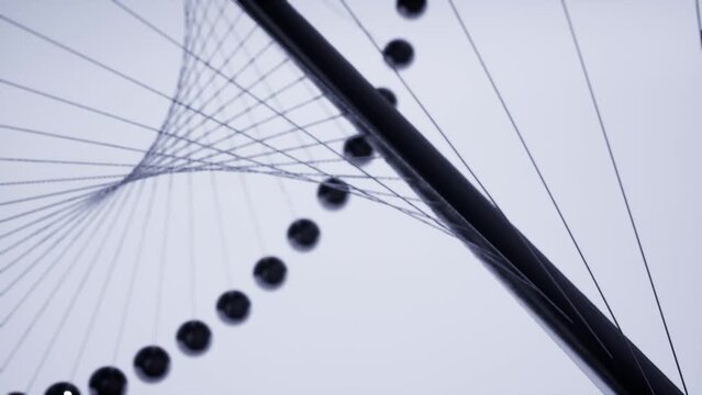 abstract modern animation of metal balls seeded on twine and spinning around a rod on a white background.