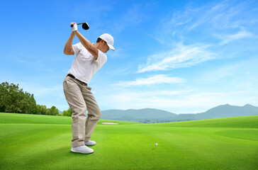 Golfer driver swing before hitting golf ball down the fairway.