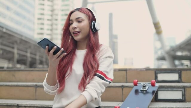 Holiday concept of 4k Resolution. Asian women listening to music in the city. teenage girl fashion.