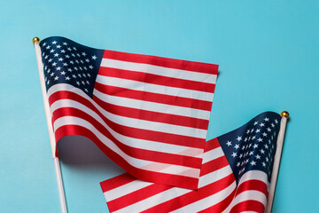 Obraz premium Small America national flags isolated on blue backgr'ound with copyspace. Space for text. USA Independence Day concept.