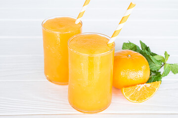 Orange smoothies yellow colorful fruit juice milkshake blend beverage healthy high protein the taste yummy In glass,drink to lose weight drink episode morning on white gray background.