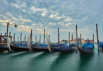 Fototapeta na wymiar Gondolas at the St. Marks square in Venice, before a dramatic sunrise