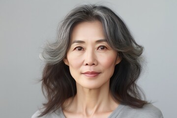 Naklejka premium Portrait of Elderly Asian Woman Posing on Grey Background on Copy Space. Beautiful Age Model. Generative AI.