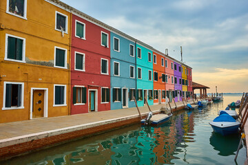 Fototapeta na wymiar Colorful architecture and canal with boats in Burano island, Venice, Italy. Famous travel destination.