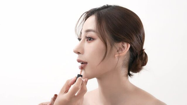 Beauty concept of 4k Resolution. Makeup artist applying lips to Asian woman on white background.