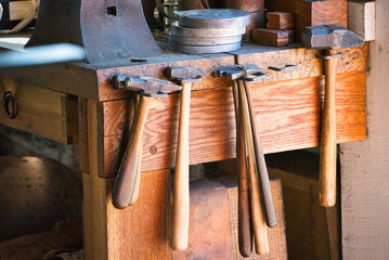 Hammers hanging on a blacksmith workbench.