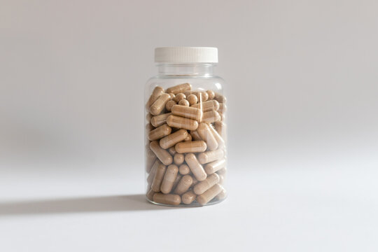 A jar with ashwagandha capsules on a white background, body supplementation, healthy diet