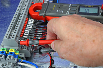 Measurement of electrical parameters in a switchboard using a digital multimeter.