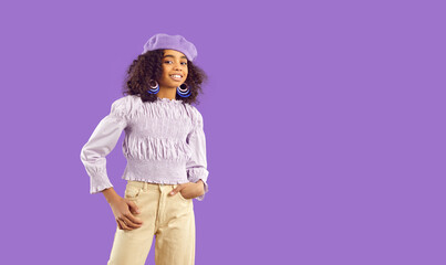 Portrait of cute curly african american preteen little girl isolated on purple background....