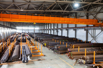 Pipes warehouse. Orange overhead crane and concrete floor