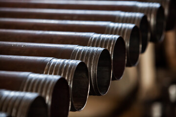 Oil drill pipes in graphite grease closeup. Low depth-of-field.
