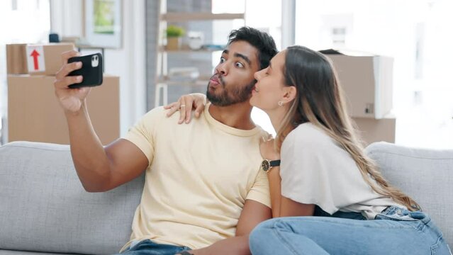 Couple, selfie kiss and peace sign, moving and bonding in .living room of new house together. Real estate, smile and self picture of man and woman kissing, v hand gesture or happy memory for property