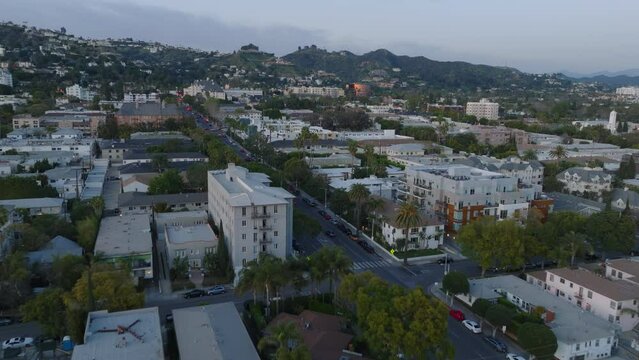 Aerial footage of multistorey residential buildings in urban borough. Residencies in hills above city in background.