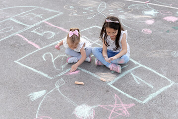 Kindergarten concept. Children drawing with   hopscotch chalk