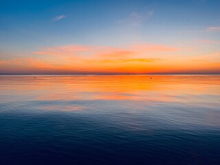 Orange sky after the sunset at the sea, evening sea horizon 