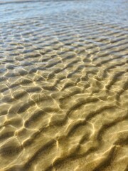 Fototapeta na wymiar Transparent sea water and sandy bottom, ripples on the sea water, natural sea water background