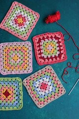 Granny squares on blue background. Top view with copy space. Handmade crocheting, needlework and...