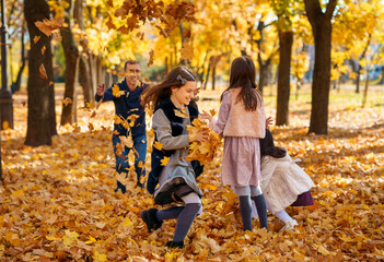 portrait of a large family with children in an autumn city park, happy people playing together and throwing yellow leaves, beautiful nature, bright sunny day