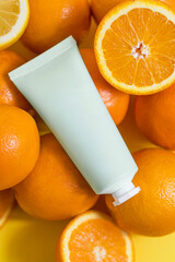 Natural vitamin c skincare products with fresh juicy orange fruit slice on orange background