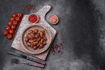 Chicken hearts fried in soy sauce with salt and spices in a plate