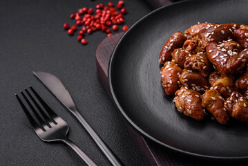 Chicken hearts fried in soy sauce with salt and spices in a plate
