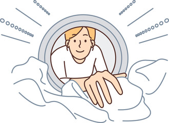 Woman looks into washing machine to get clean clothes while doing housework and taking care hygiene