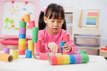 young girl was making colorful craft at home