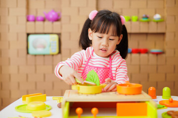 young girl pretend playing food preparing at home