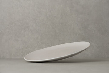 Empty plate falling on the table. Levitation, flying saucer.