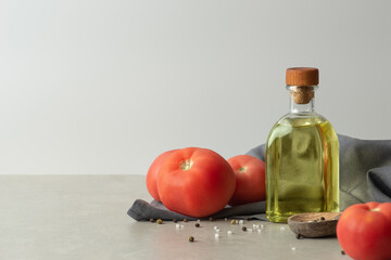 Culinary background with vegetable oil, spices and towel. Gray wall and table