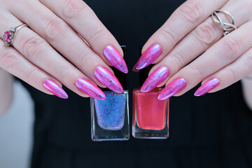 Woman hand with long nails manicure and light pink and blue nail polish