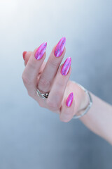 Woman hand with long nails manicure and light pink and blue nail polish