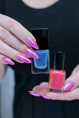 Woman hand with long nails manicure and light pink and blue nail polish
