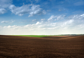 colorful hills of plowed dark land and green fields panoramic view