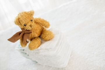 teddy bear sitting on pile of diapers