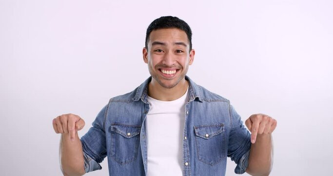 Happy, face and an Asian man pointing with a thumbs up isolated on a white background in a studio mockup. Smile, portrait and a person with a gesture for branding, advertising and promotion support
