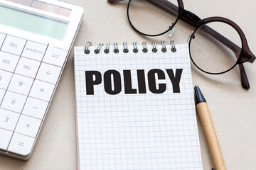The word POLICY in an office notebook.