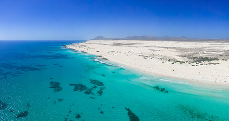 Beautiful mid level aspect aerial panoramic view of Grandes Playa beach with clear turquoise water near Corralejo in Fuerteventura Spain - obrazy, fototapety, plakaty