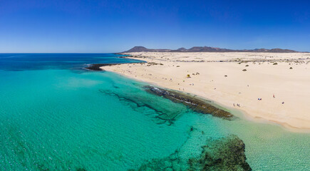 Beautiful high aspect aerial panoramic view of the white sandy beach of Playa del Dormidero near Corralejo in Fuerteventura Canary Islands Spain