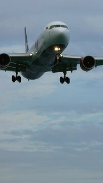 Passenger airplane before landing at morning. Vertical video