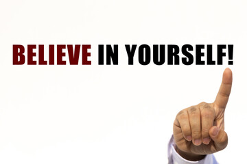 Believe in yourself text on white wall background with businessman's finger point at the message with empty space. This message can be used as business concept about believe in yourself.