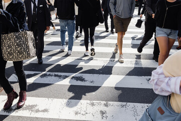 crowd of people crossing a city street at the zebra crossing
