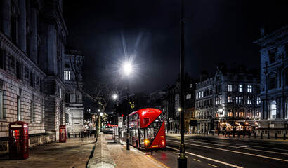 A red double decker in the night on Parliament street in London