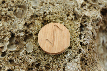 Wooden rune Eihwaz on stone outdoors, closeup