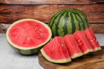 Juicy ripe cut and whole watermelons on white table, closeup