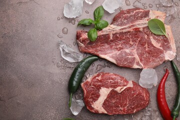 Flat lay composition with cut fresh beef meat on brown table. Space for text