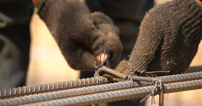 hand of construction worker with fabricating steel reinforcement bar,Workers are using steel wire to bind steel bars